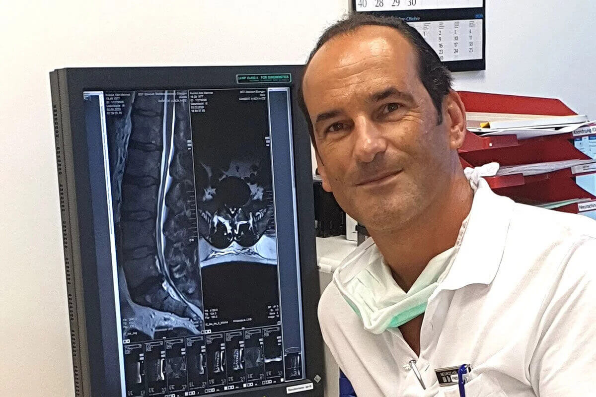 Dr. med. René Hebecker neben einem MRI-Bild, das medizinische Details zeigt.