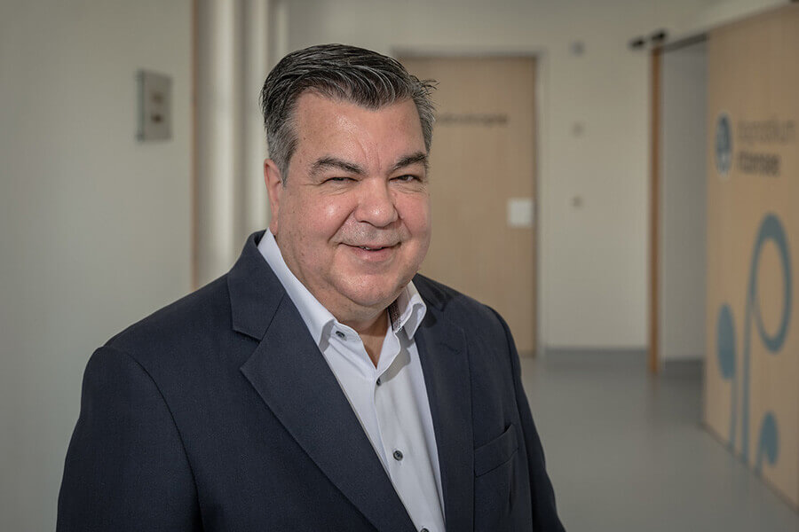 Lächelnder Mann in Anzug in der Privatklinik Ritzensee, freundliche Atmosphäre.