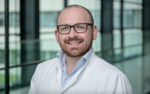 Dr. med. Stephan Hruby lächelt fachkundig in der Privatklinik Ritzensee.