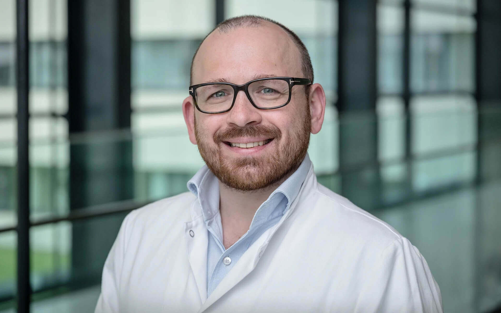 Dr. med. Stephan Hruby lächelt fachkundig in der Privatklinik Ritzensee.