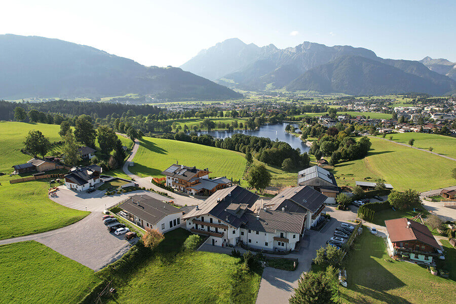 Luftaufnahme der Privatklinik Ritzensee im malerischen Salzburger Land mit Bergen und Wiesen.