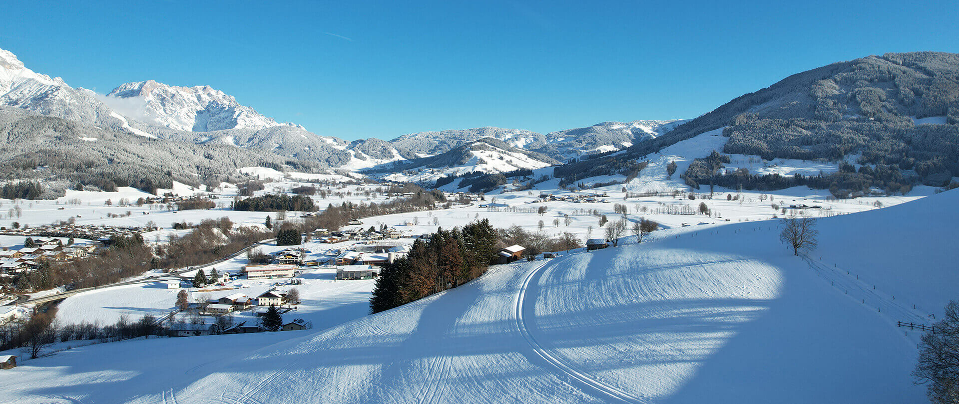 Winterliche Aussicht auf das malerische Salzburger Land mit schneebedeckten Bergen und Dörfern.
