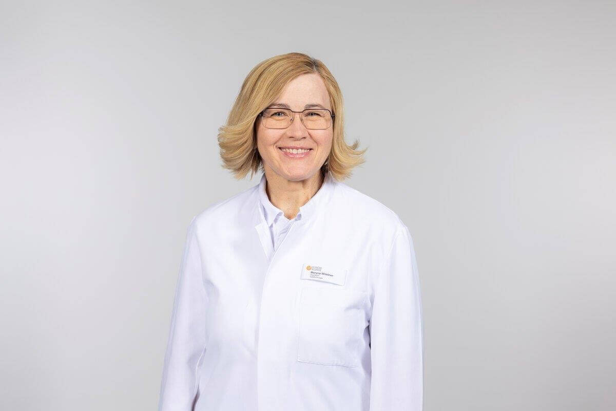 Dr. Maryna Wüstner in weißem Kittel, lächelt freundlich für die Privatklinik Ritzensee.